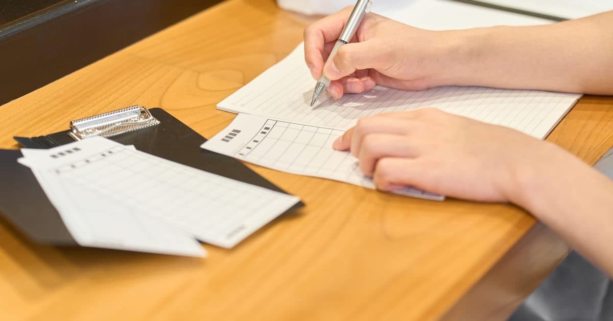 Close-up of a student working through practice questions on ruled paper