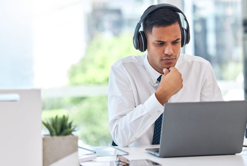 Aspirant listening to subject-wise audio notes at a laptop
